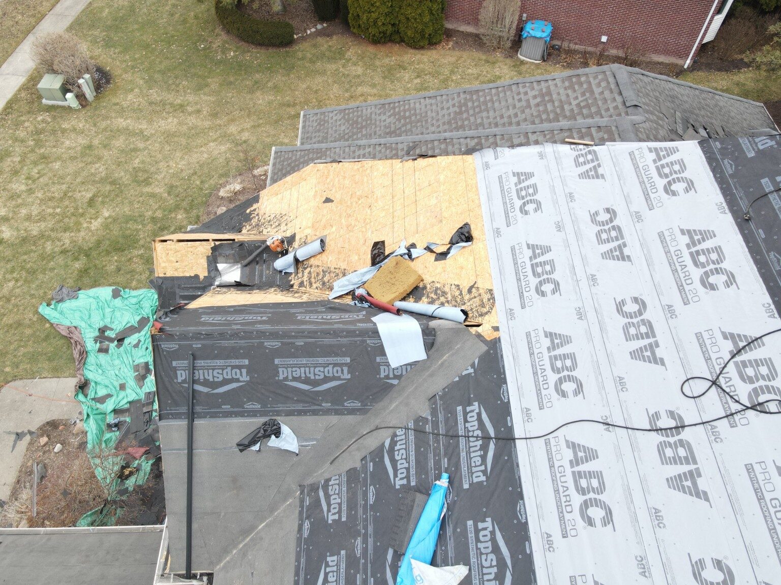 Roofers replacing decking and preparing a complex roof section