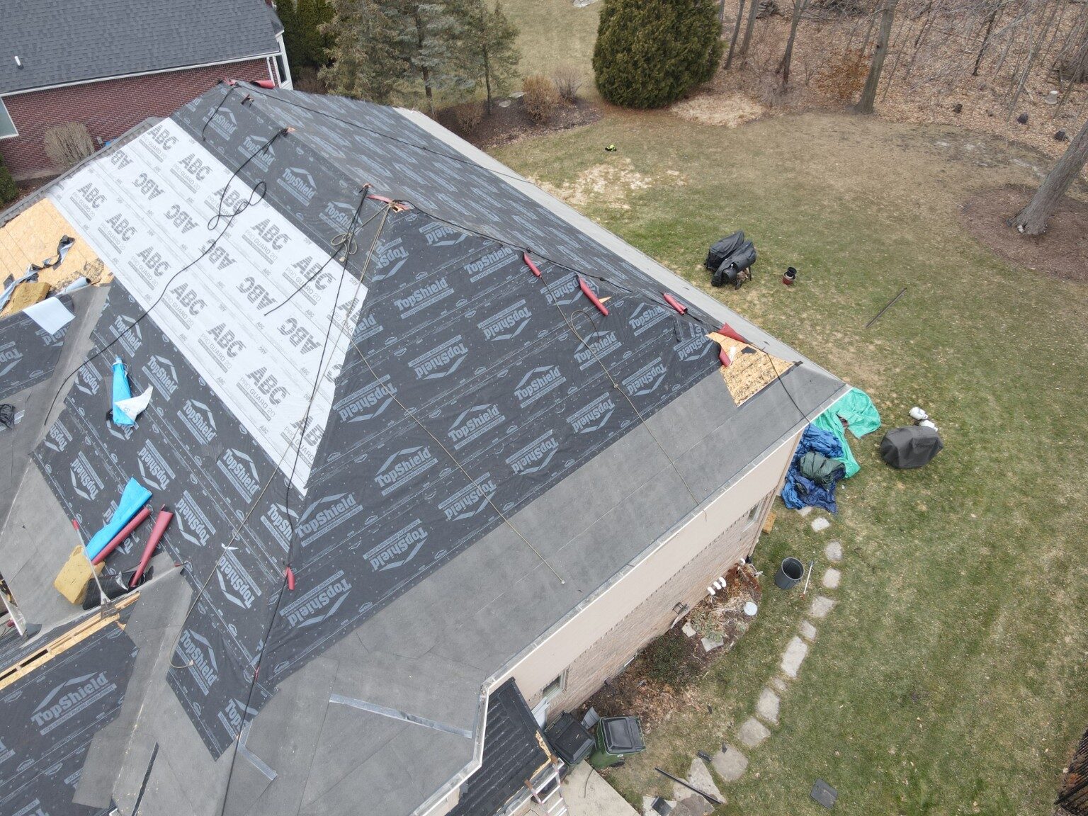 Roofing crew working on underlayment and shingle installation