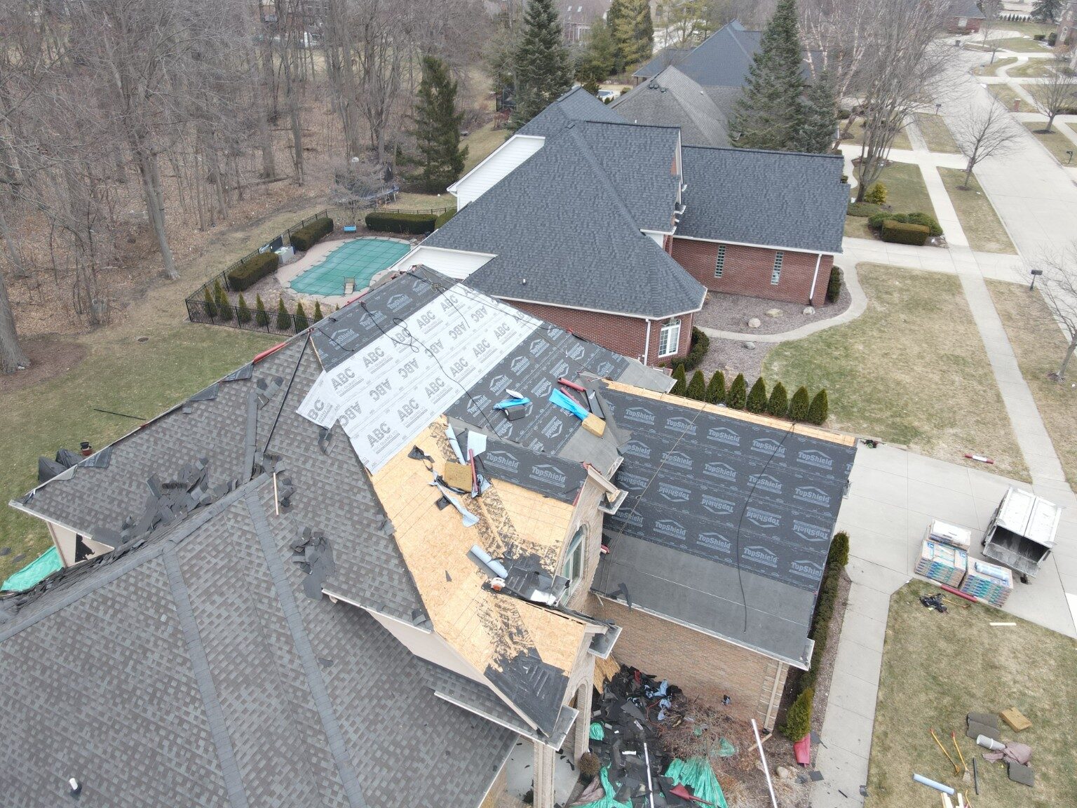 Drone view of a roofing crew completing a large residential project