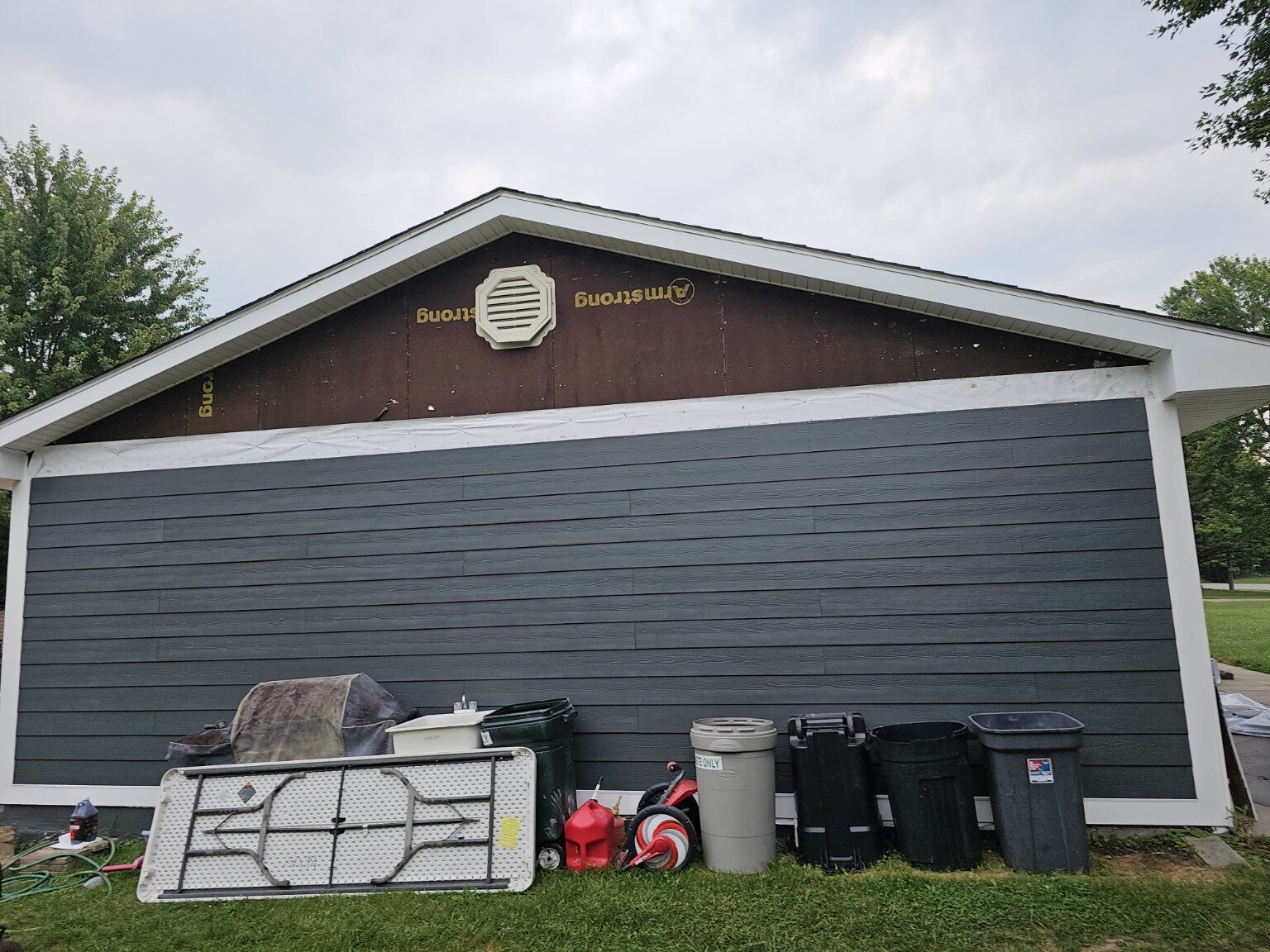 Dark horizontal Hardie board siding installed on a gable wall