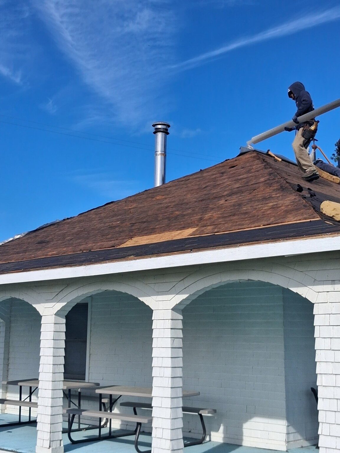 Roofers installing architectural shingles on the pavilion