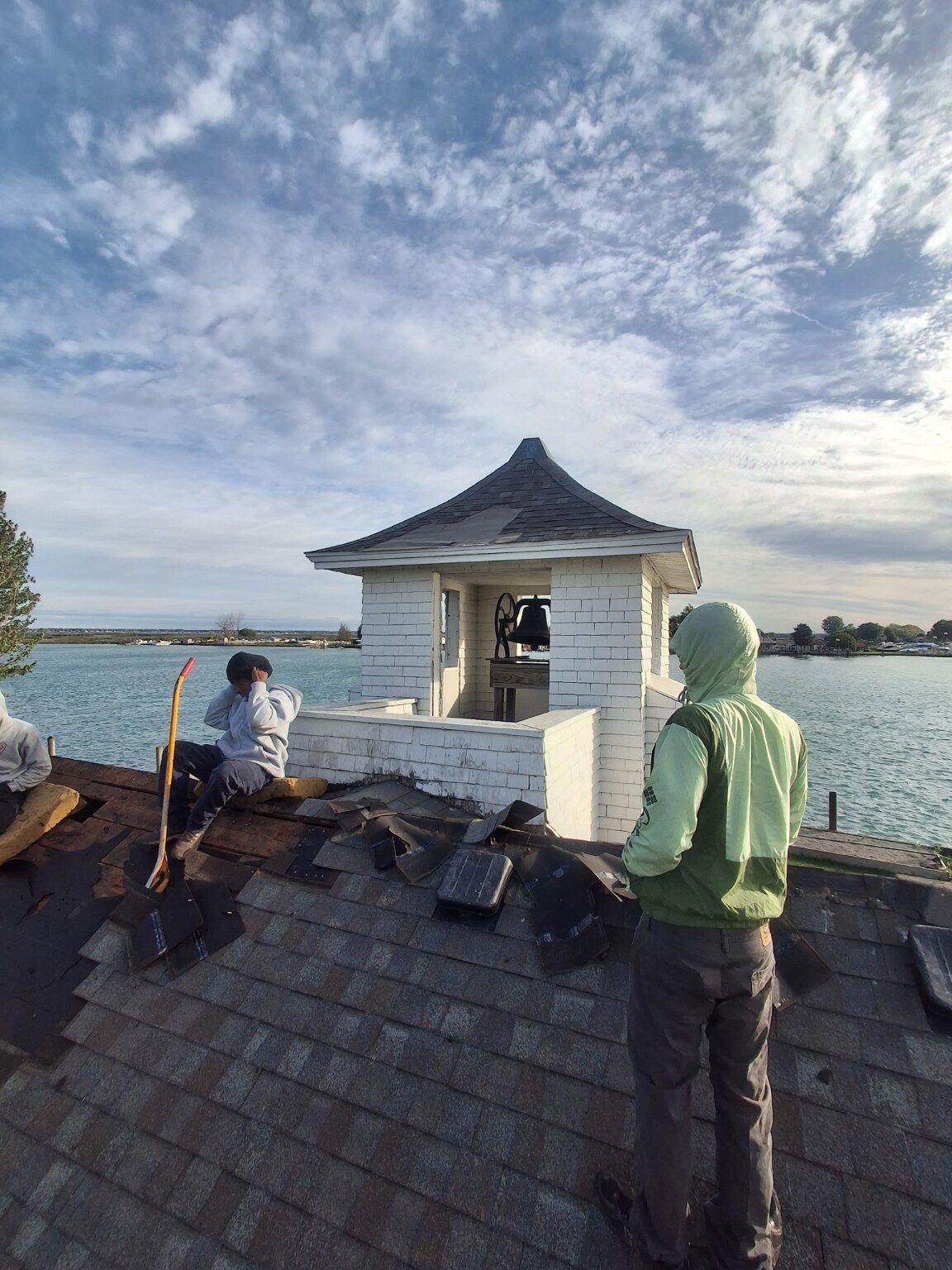 Roofing crew completing shingle installation near the pavilion cupola